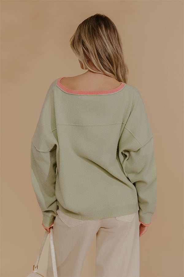 Oversized Knit Top with Coral Accents and Exposed Seam Detailing